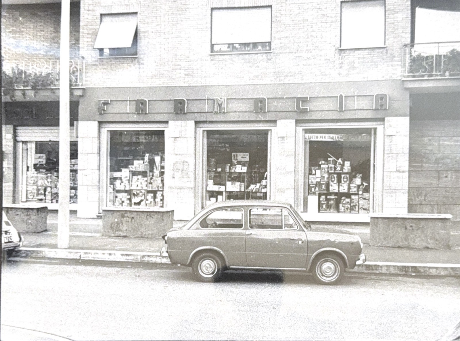 La facciata storica della Farmacia dei Gelsi con un’auto d’epoca in sosta